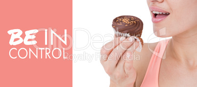 Composite image of smiling brunette holding chocolate cupcake