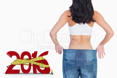 Composite image of back of woman holding her too big jeans