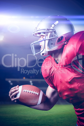 Composite image of side view of aggressive sportsman playing american football