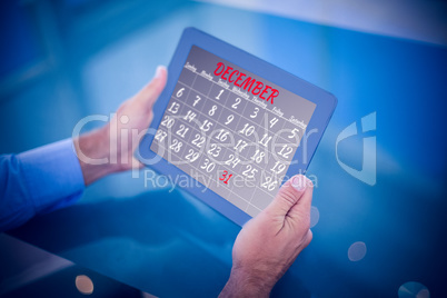 Composite image of businessman using his tablet