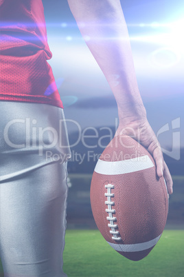 Composite image of cropped image of american football player holding ball