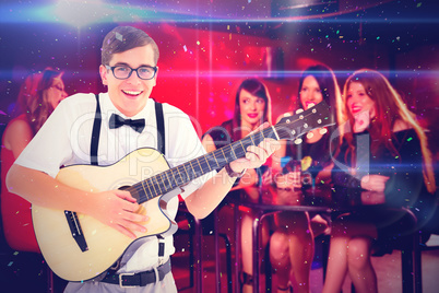 Composite image of geeky hipster playing guitar and singing