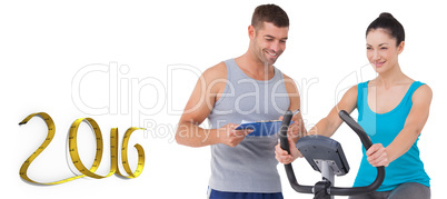 Composite image of trainer with client on exercise bike
