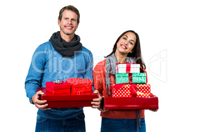 Festive couple smiling and holding gifts