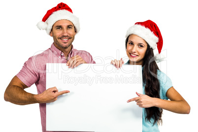 Festive couple showing a sign