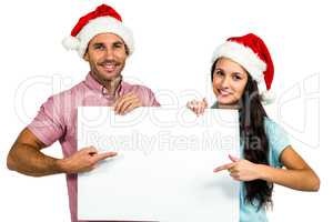 Festive couple showing a sign