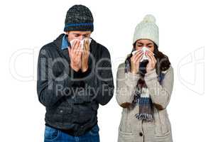 Winter couple blowing their noses