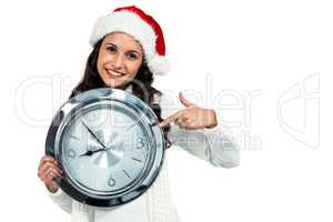 Attractive woman with christmas hat holding clock
