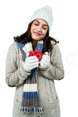 Festive brunette holding hot drink