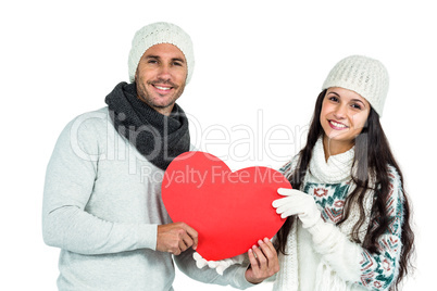 Smiling couple holding paper heart