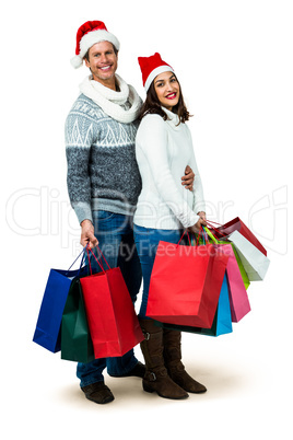 Festive couple smiling and holding gift bags