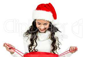 Happy woman with christmas hat looking in red shopping bag