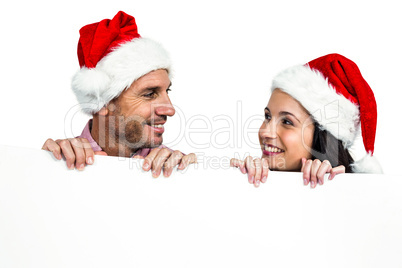 Festive couple showing a sign