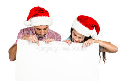 Festive couple showing a sign