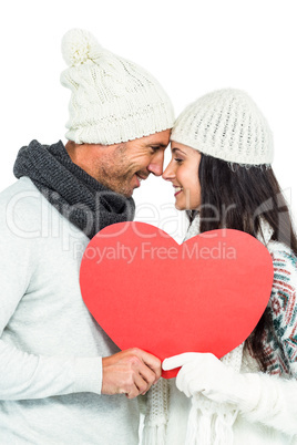 Smiling couple holding paper heart