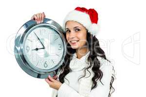 Attractive woman with christmas hat holding clock