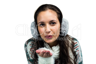 Smiling woman with earmuffs blowing kiss