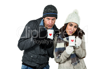 Winter couple enjoying hot drinks