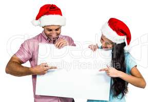 Festive couple showing a sign