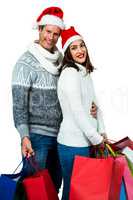 Festive couple smiling and holding gift bags