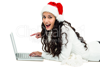 Smiling woman using laptop laying on floor