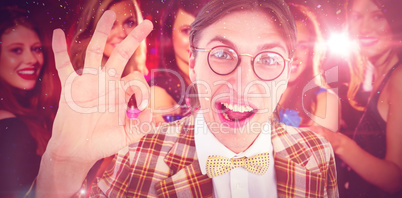 Composite image of geeky hipster doing the ok sign