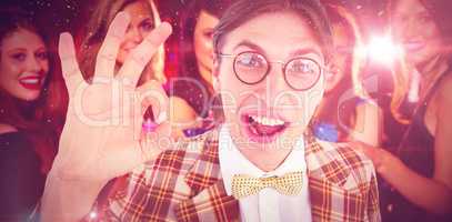 Composite image of geeky hipster doing the ok sign