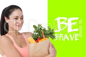 Composite image of slim woman holding bag with healthy food