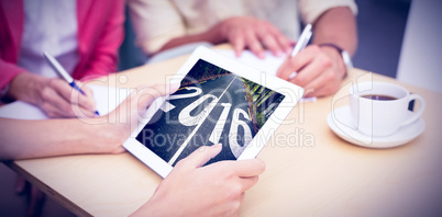 Composite image of creative team using tablet pc