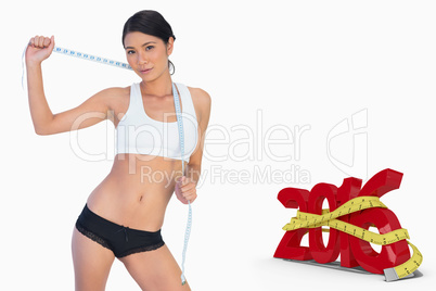 Composite image of self confident slim woman holding her measuri