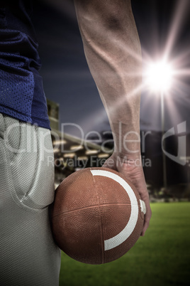 Composite image of close-up of american football player holding ball