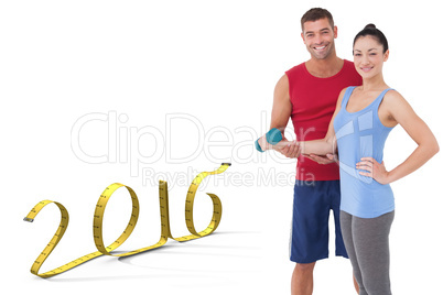 Composite image of fit woman and trainer smiling at camera