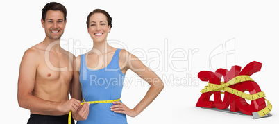 Composite image of fit young man measuring womans waist