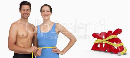 Composite image of fit young man measuring womans waist