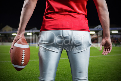 Composite image of mid section of sportsman with american football