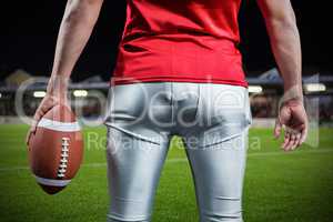 Composite image of mid section of sportsman with american football