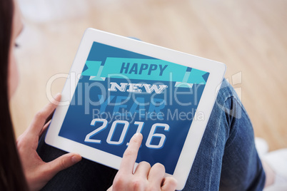 Composite image of teen using a tablet pc sitting on the floor