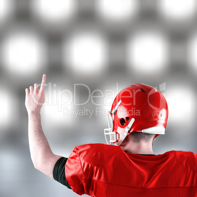 Composite image of rear view of american football player triumph