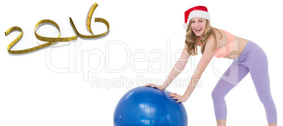 Composite image of festive blonde woman using exercise ball