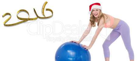 Composite image of festive blonde woman using exercise ball