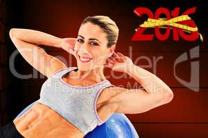 Composite image of fit woman doing sit ups on blue exercise ball