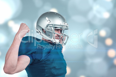 Composite image of confident american football player flexing mu