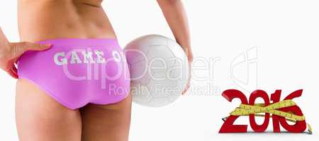 Composite image of fit girl in pink bikini holding ball