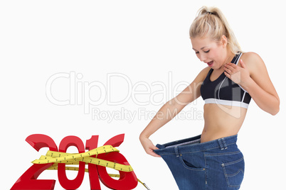 Composite image of young thin woman wearing old pants after losi