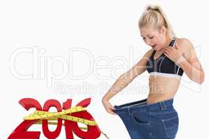 Composite image of young thin woman wearing old pants after losi