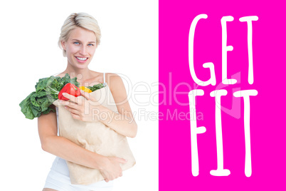 Composite image of attractive woman holding bag of vegetables Composite image of attractive woman holding bag of vegetables