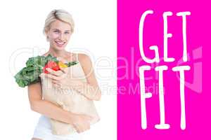 Composite image of attractive woman holding bag of vegetables