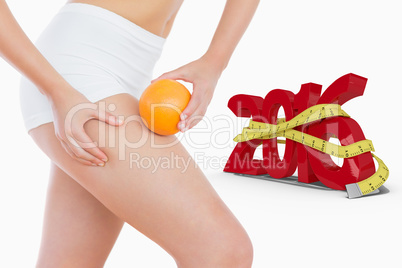 Composite image of fit woman squeezing fat on thigh as she holds