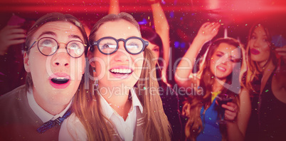 Composite image of geeky hipster couple raising eyes