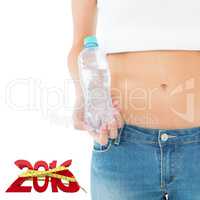 Composite image of mid section of a fit woman holding a bottle o